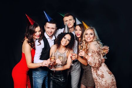 Friends birthday party. Six people having fun and drinking champagne on black backgroundの写真素材