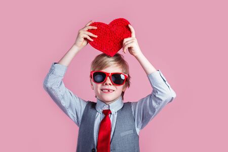 Stylish boy in red glasses posing with heartの写真素材