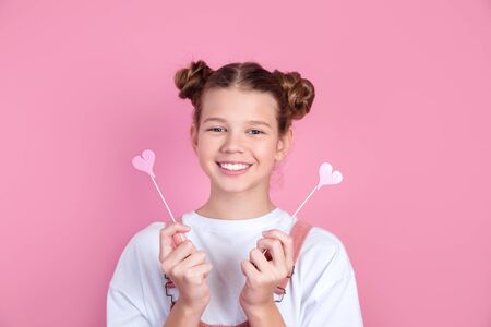 beautiful girl fooling around,with pink hearts on pink backgroundの写真素材