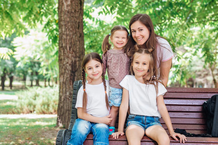 Mother and daughters relaxing in park. Family time