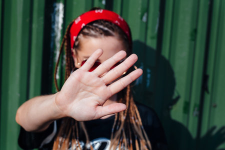 Woman raised her hand for dissuade, campaign stop violence against women on city street outdoor