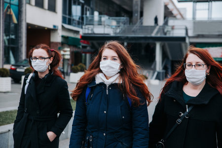 Coronavirus epidemic in Europe. People wearing face masks on city street.の写真素材