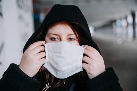 Woman wearing a face mask against pollution or disease in cityの写真素材