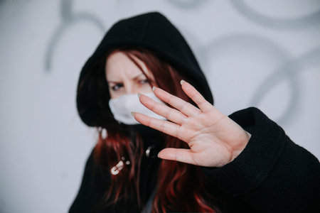 Stop the infection. Woman showing gesture stop. Photo of woman wear protective mask against...
