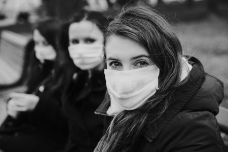 people wearing medical masks during flu or contagious pandemic in parkの写真素材