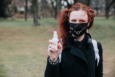 Woman in medical mask Washing hands by alcohol sanitizers from bottleの写真素材