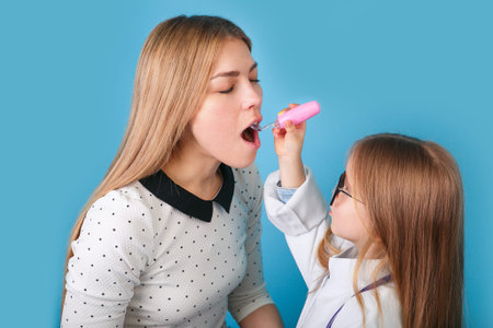 Adorable child dressed as doctor playing with her motherの写真素材