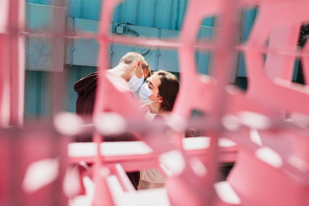 Loving couple kisses in medical masks in city street
