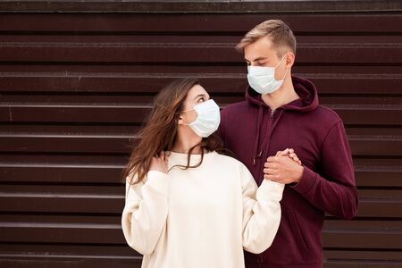 Young couple with face masks in time of virus pandemic in cityの写真素材