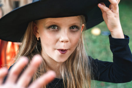 Little girl in witch costume having fun on Halloween trick or treat