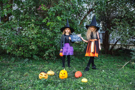 Halloween little girls in witch costume out for trick-or-treatingの写真素材
