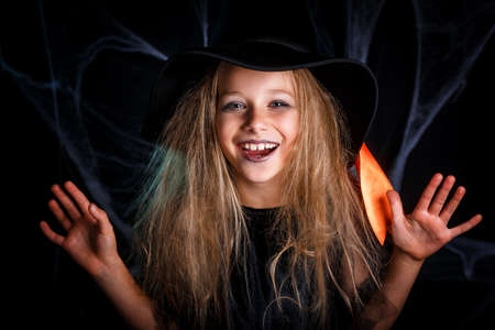 Little girl in witch costume having fun on Halloween trick or treat.の写真素材