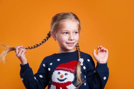 Funny little girl in a Christmas sweater is having fun. Happy New Year and Christmas