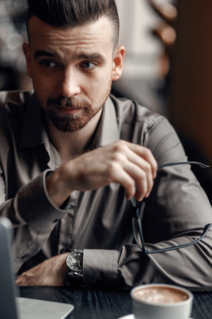 Portrait of a handsome casual businessman with black eyeglasses in cafeの写真素材