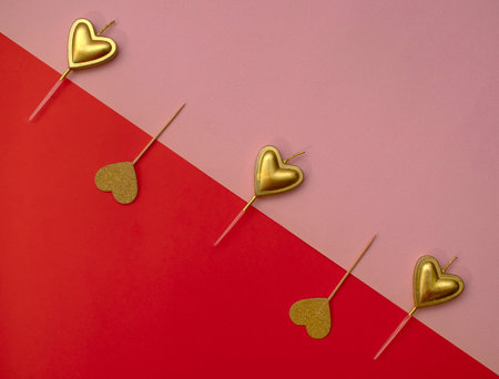 Golden hearts on pink and red background. Valentine's day inspiration. Love aesthetic.の写真素材