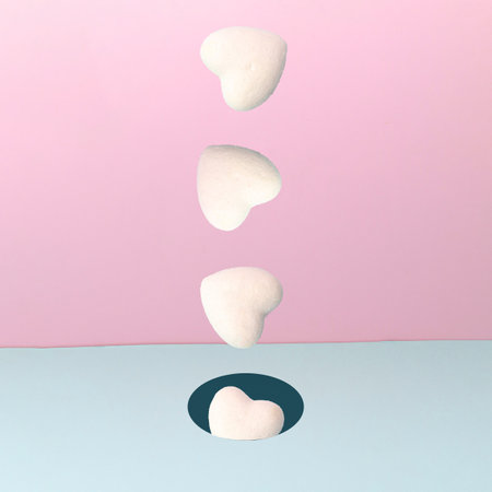 White hearts falling on blue and pink backdrop. Minimal composition. Valentine's or Birthday presents.の写真素材