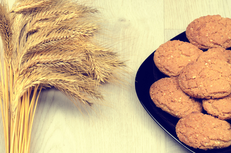 wheat ears and cookies on a wooden backgroundの写真素材