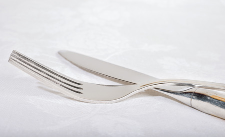 fork and knife on a white napkinの写真素材
