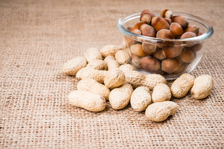 tasty nuts on glass bowl and burlap
