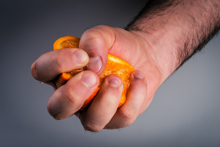 Male hand squeezing orange.の写真素材