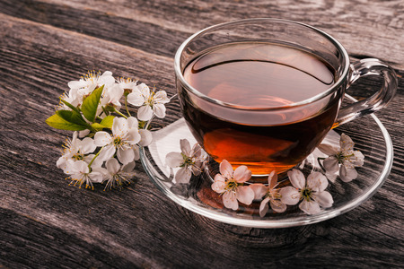 cup of tea with spring flower cherry blossom on a wooden rustic background. Vintage style.の写真素材