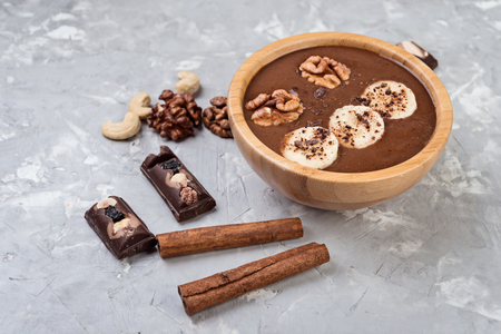 Chocolate smoothie on a bowl with banana and nuts on grey stone  backgroundの写真素材
