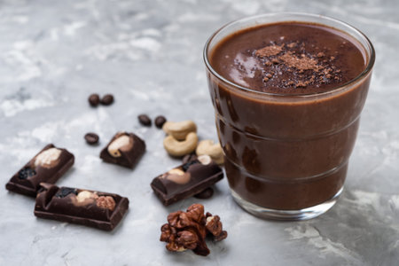 Chocolate smoothie on a glass with coffee beans and nuts on grey stone  backgroundの写真素材