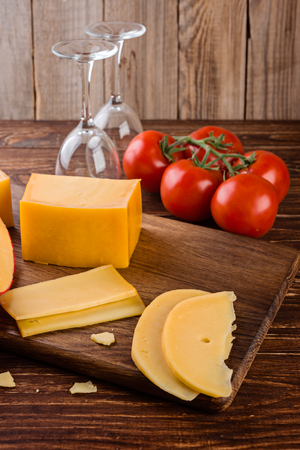 Cheese assortment and tomates on a on wooden background, selective focusの写真素材