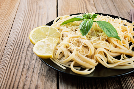Italian spaghetti   with  cheese and fresh basil - homemade healthy italian pasta on rustic wooden background.の写真素材