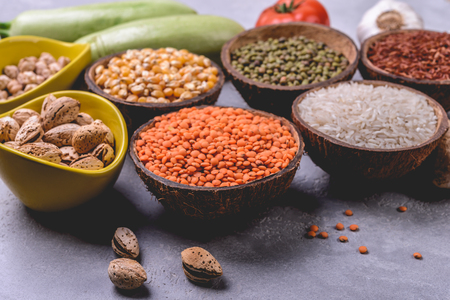 Different   grains, seeds, beans  in ceramic bowls  on grey concrete tableの写真素材