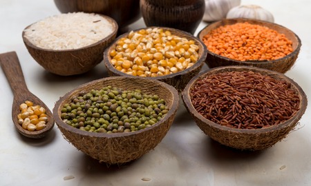 cereals, seeds, beans, grains in a bowls on white tableの写真素材