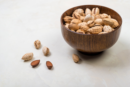 raw almonds in a wooden bowlの写真素材
