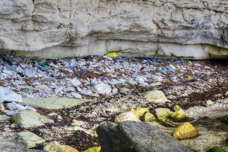 Seashore with plastic and polyethylene waste, packages, bottles, environmental problem of the 21st century, non-degradable plastic, disposable dishes and a sad result of a dirty beachの写真素材
