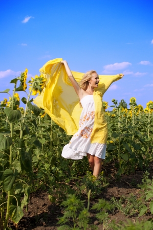Young beautiful woman in a field of sunflowersの写真素材