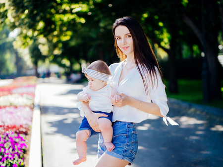 Mother with 8 month baby girl spend time in a parkの写真素材