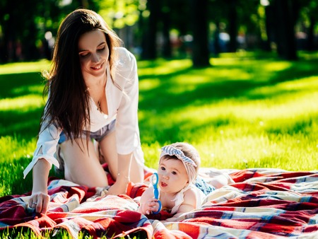 Mother with 8 month baby girl spend time in a parkの写真素材