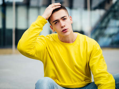 Young attractive man in a yellow sweaterの写真素材