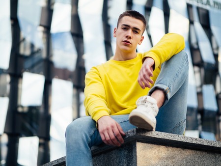 Young attractive man in a yellow sweaterの写真素材