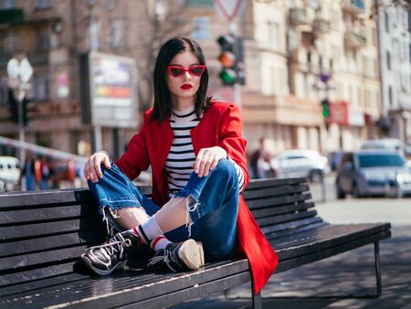 Beautiful glamorous brunete girl in a red jacket posingの写真素材
