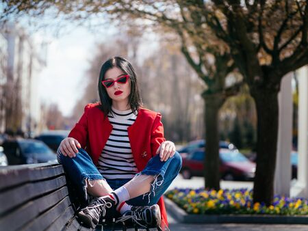 Beautiful glamorous brunete girl in a red jacket posingの写真素材