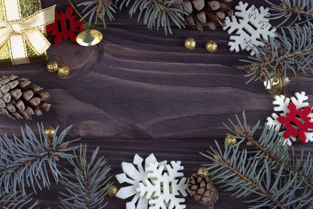 Christmas Xmas New Year holiday decoration with golden bells balls red white snowflakes natural fir branches and cones on dark wooden background, closeup, card consept, empty spaceの写真素材