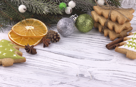 Christmas Xmas New Year holiday Decoration with dried oranges cookies star anise cinnamon cones natural fir branches red balls on white wooden backgroundの写真素材