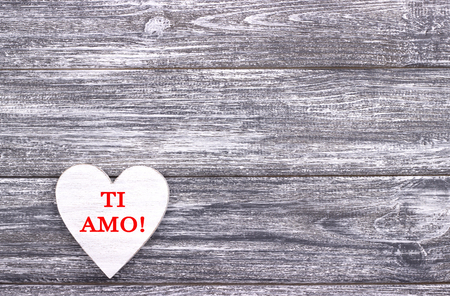 Decorative white wooden heart on grey wooden background with lettering I Love You in Italian. Valentines day card. Weddingの写真素材