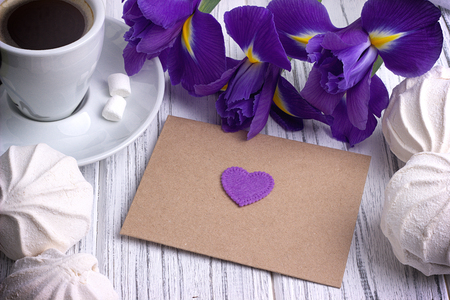 Still life with envelop heart sign iris flowers on white wooden background. Wedding. Valentines Day conceptの写真素材