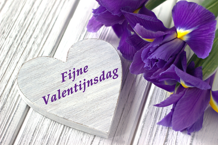 Still life with heart sign iris flowers on white wooden background. Wedding. Valentines Day greeting card with text Happy Valentines Day in Dutch. Loveの写真素材