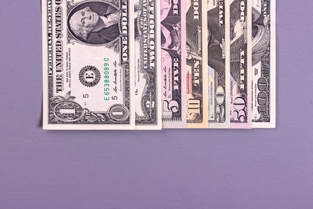 Pile of dollar bills of different denominations on gray backgrondの写真素材