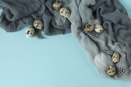 Easter decoration with quail eggs,gray fabric on blue background.の写真素材