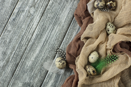 Easter decoration with quail eggs beige fabric gray wooden background.の写真素材