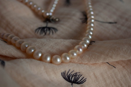 Heart shaped pearl necklace on the light linen background. Romantic background. Front view. Macro.