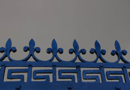 Close up of a old forged iron fence with arrows.